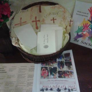 A display of church programs and brochures arranged in a basket on a table.