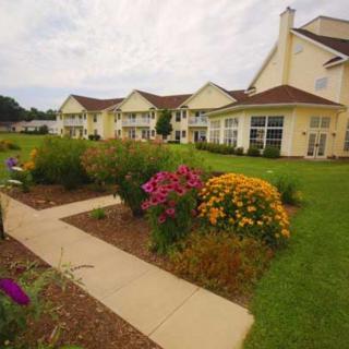 A landscaped garden with colorful flowers and a paved pathway alongside residential buildings.