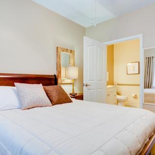 A cozy bedroom with a neatly made bed and adjoining bathroom.