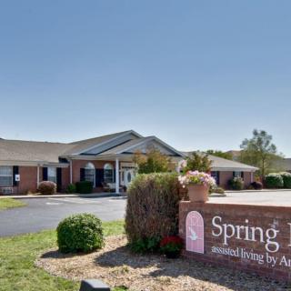 An exterior view of an assisted living facility with a sign reading 'Spring Arbor Assisted Living by Americare'.