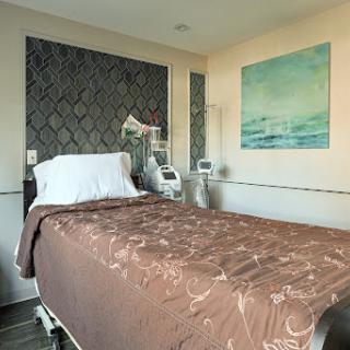 A well-appointed hospital patient room featuring a comfortable bed and medical equipment.