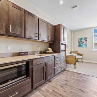 A modern kitchen with wooden cabinets and a cozy dining area.