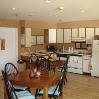 A cozy kitchen and dining area with wooden furniture and essential appliances.