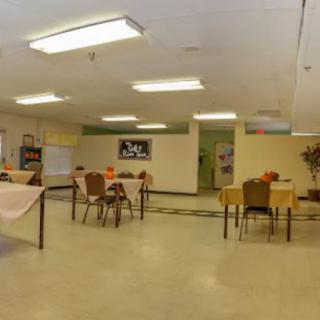 An indoor cafeteria with tables and chairs arranged neatly, featuring decorative elements.
