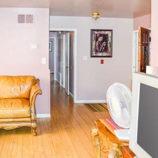 A cozy living room with a sofa, television, and a hallway leading to other rooms.