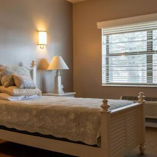 A cozy bedroom with a neatly made bed and soft lighting.