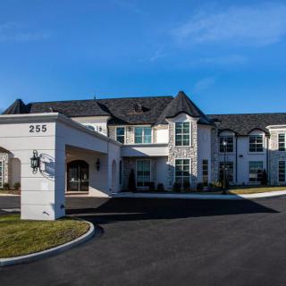 A modern two-story residential building with classic architectural features.