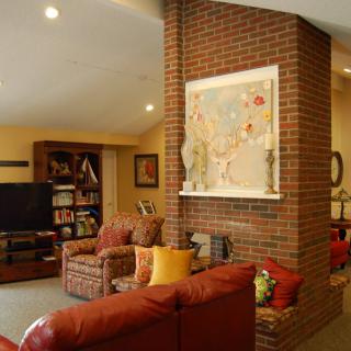 A cozy living room featuring a large brick wall, comfortable seating, and decorative elements.