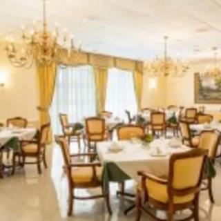 An elegant dining room with chandeliers and neatly arranged tables and chairs.