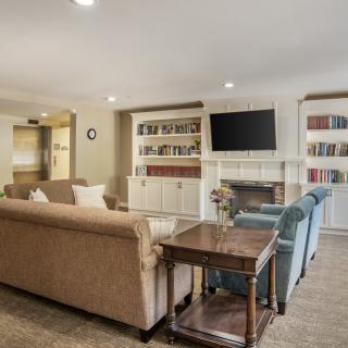A cozy living room with a sofa, television, bookshelves, and a coffee table.