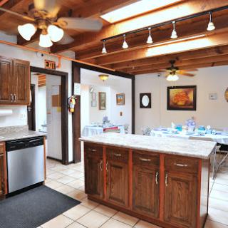 A spacious and inviting kitchen featuring wooden cabinetry, an island counter, and plenty of natural light.