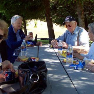 A group of seniors enjoying a picnic at a park.