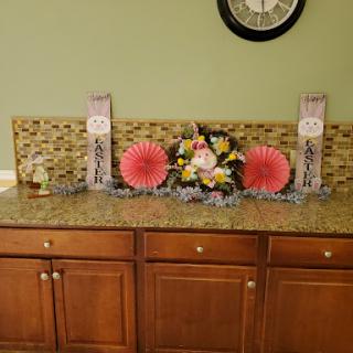 A beautifully arranged kitchen countertop featuring floral decor and decorative signs.