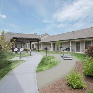 A peaceful courtyard with landscaped gardens and a pathway between buildings.