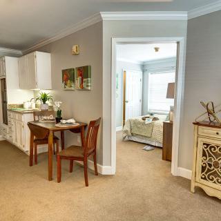 A cozy home interior featuring a compact kitchen and dining area leading into a living room.