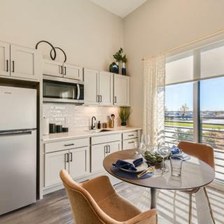 A modern kitchen and dining area with ample natural light and a compact, stylish design.