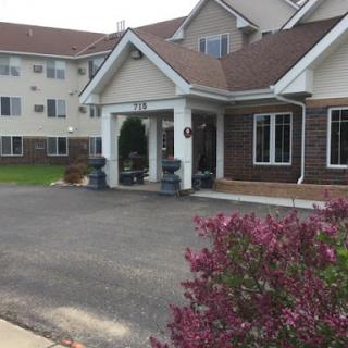 The welcoming entrance of a residential building surrounded by vibrant landscaping.