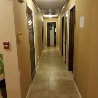 A well-lit indoor hallway with multiple doors on either side.