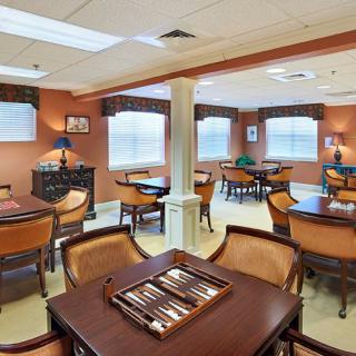 A cozy game room with tables and chairs, featuring a backgammon set ready for play.