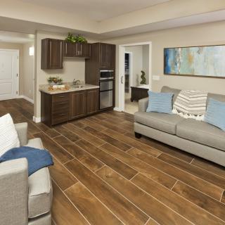Modern living room with open kitchen and wooden flooring.