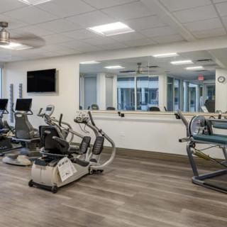 A modern gym with various exercise machines and cardio equipment.