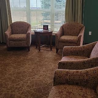A cozy seating area featuring patterned chairs and a side table by a large window.