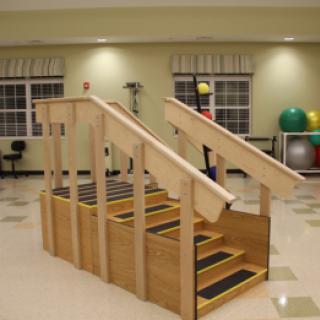 A wooden stairway designed for physical therapy, featuring multiple steps for rehabilitation exercises.