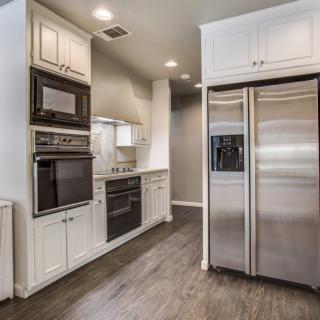 A modern kitchen with stainless steel appliances and white cabinetry.