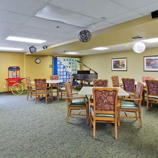 A cozy dining room with tables and chairs, featuring a popcorn machine and decorative elements.