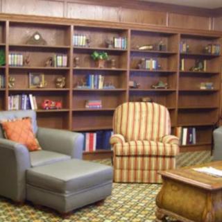 A cozy library room with bookshelves and comfortable seating.