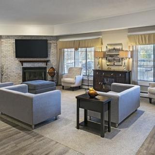 A spacious and elegantly designed living room featuring modern furniture, a fireplace, and large windows.
