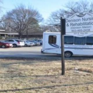 A view of a nursing and rehabilitation center parking lot with a shuttle vehicle and signage.