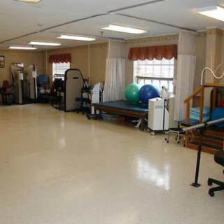 A well-equipped rehabilitation and physical therapy room with various exercise machines and tools.