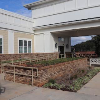 A modern building entrance with a landscaped pathway and accessibility features.
