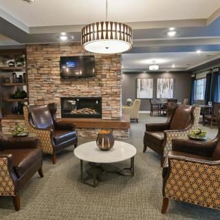 A cozy and modern living room with a stone fireplace and comfortable seating arrangement.