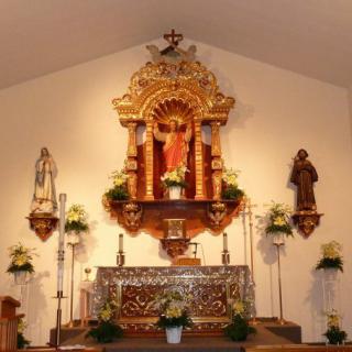 A beautifully adorned church altar with religious statues and floral decorations.