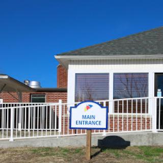 The main entrance of a building with clear signage and a bright blue sky.