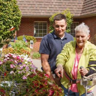 A joyful moment in the garden, showcasing the bond between generations as they tend to beautiful flowers.