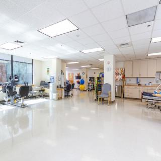 An interior view of a modern clinic with medical equipment and chairs.