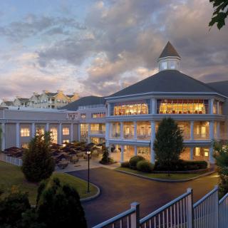 A grand hotel building illuminated in the evening with well-maintained landscaping.