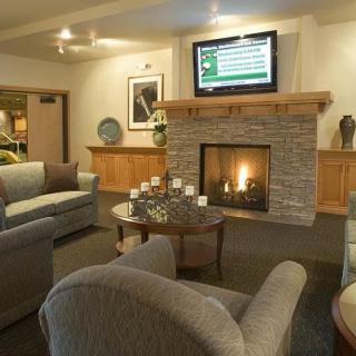A cozy living room with comfortable seating, a fireplace, and a television.