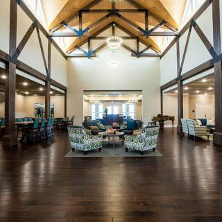 A spacious modern lounge area with wooden beams and a high ceiling.