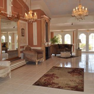 An elegant lobby with chandeliers, plush furniture, and a large mirror.