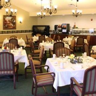 A well-appointed restaurant dining room with elegantly set tables and comfortable chairs.