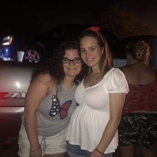 Two friends posing together at night.