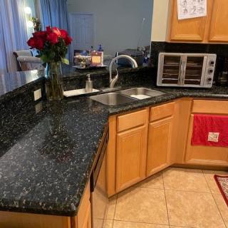 A kitchen with granite countertops, a sink, and a small oven.