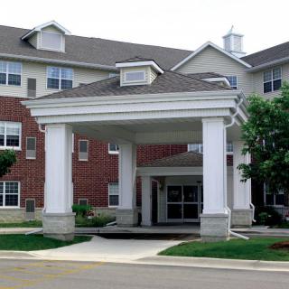 A residential building with a covered entrance and brick facade.