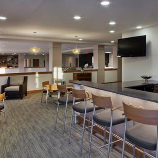 A modern hotel lobby with a stylish bar area, comfortable seating, and ambient lighting.