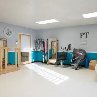 A bright and organized physical therapy room, equipped with various exercise tools for rehabilitation.