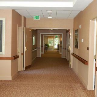 An empty hallway with multiple doorways and beige walls inside a building.